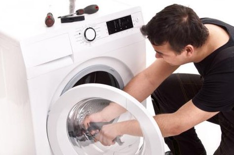 Professional technician repairing washing machine